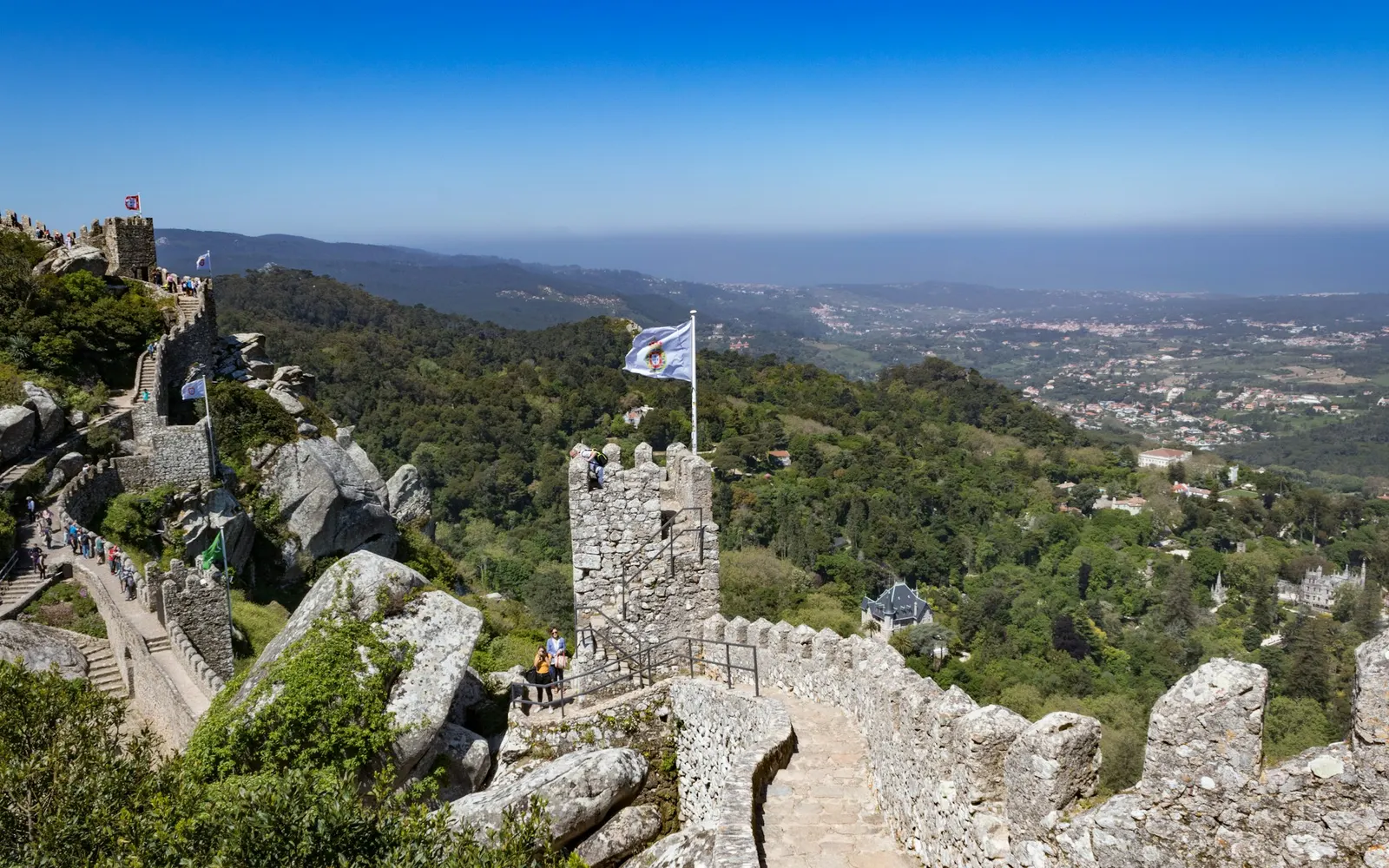 Bayrakların dalgalandığı ve Sintra vadisinin aşağıda uzandığı Castelo dos Mouros'un Kraliyet Kulesi